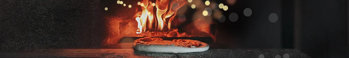 Photo of pizza being cooked in an fired oven