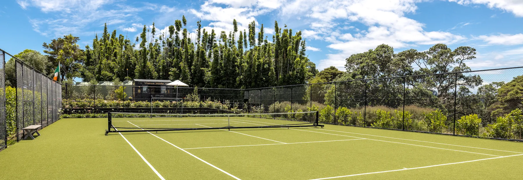 Photo overlooking the tennis court with the small pub in the distance