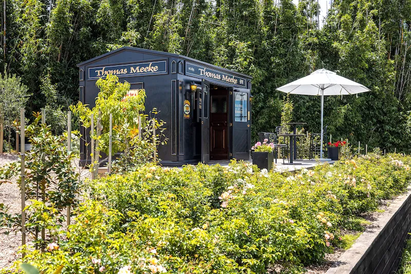 Photo of the outside of the pub, with a garden in the foreground