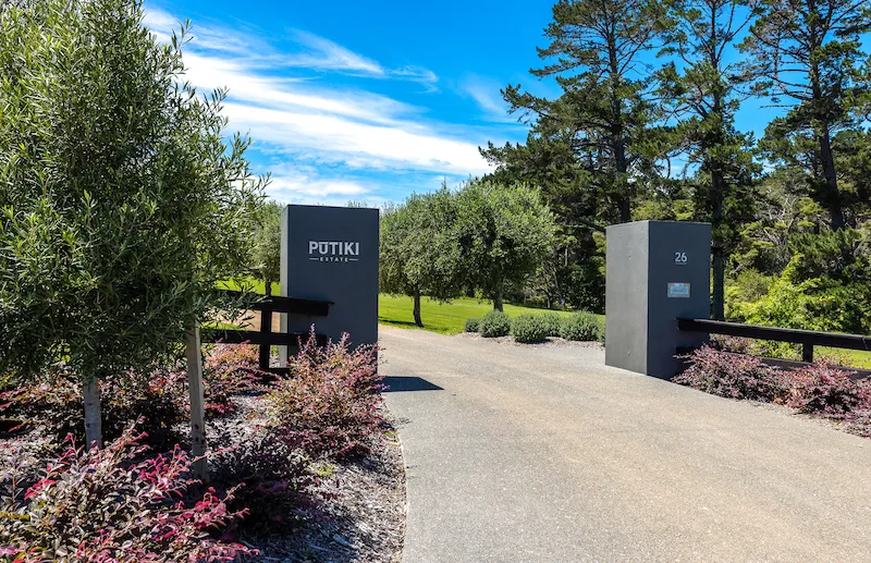 Photo of the front gate of the property, with the logo on one of the pillars