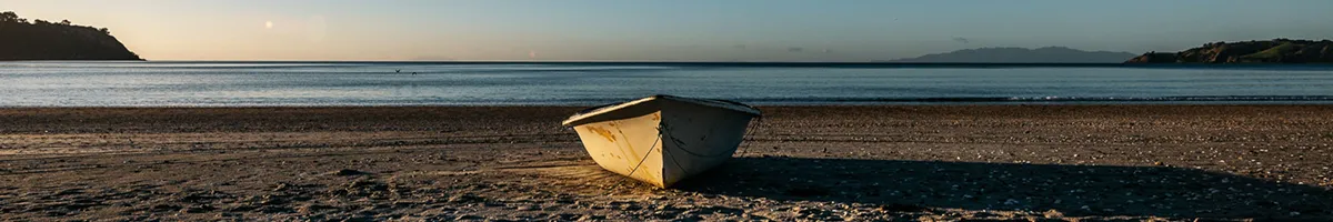 A photo of a small boat on a sandy beach