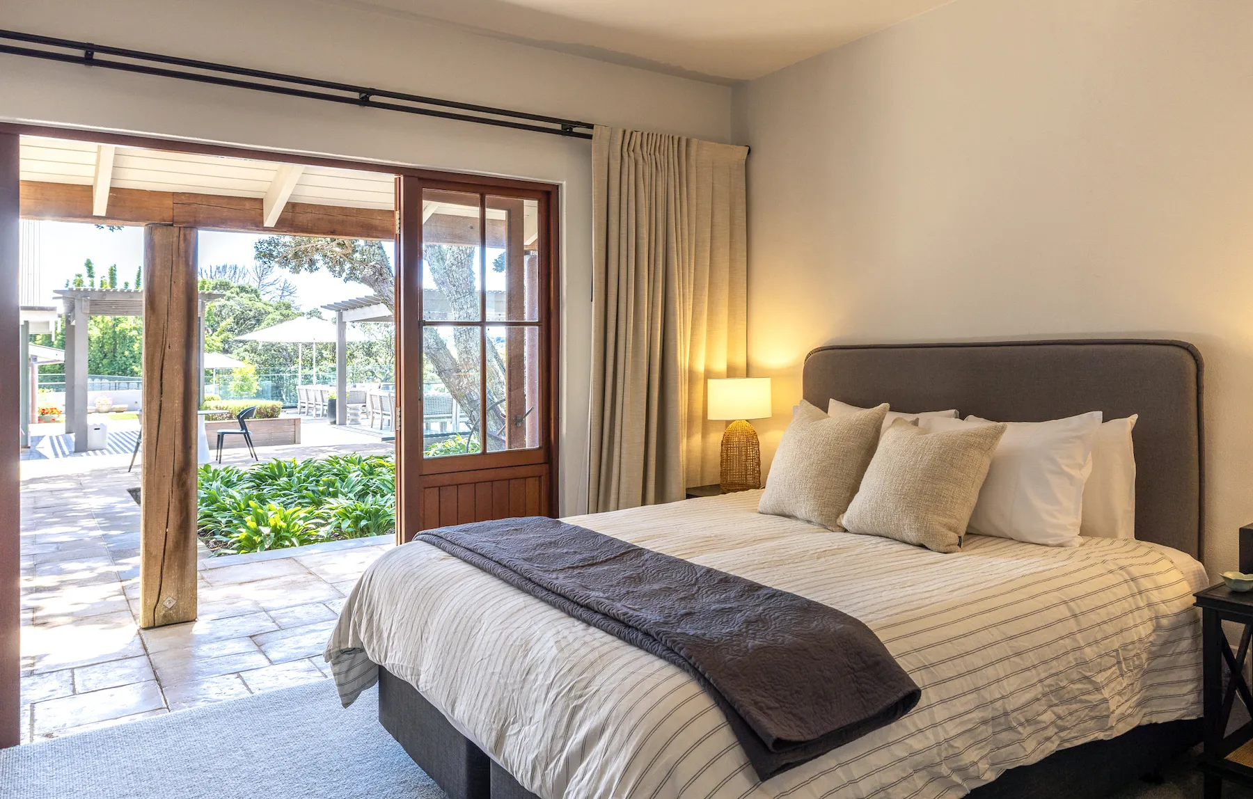 Photo of a large bed with doors open to a garden