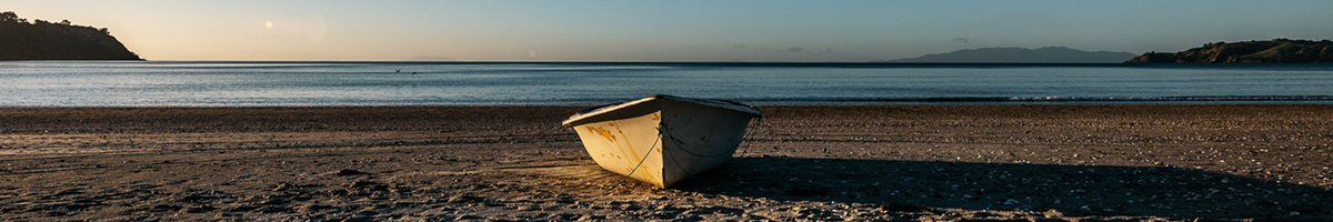 A photo of a small boat on a sandy beach